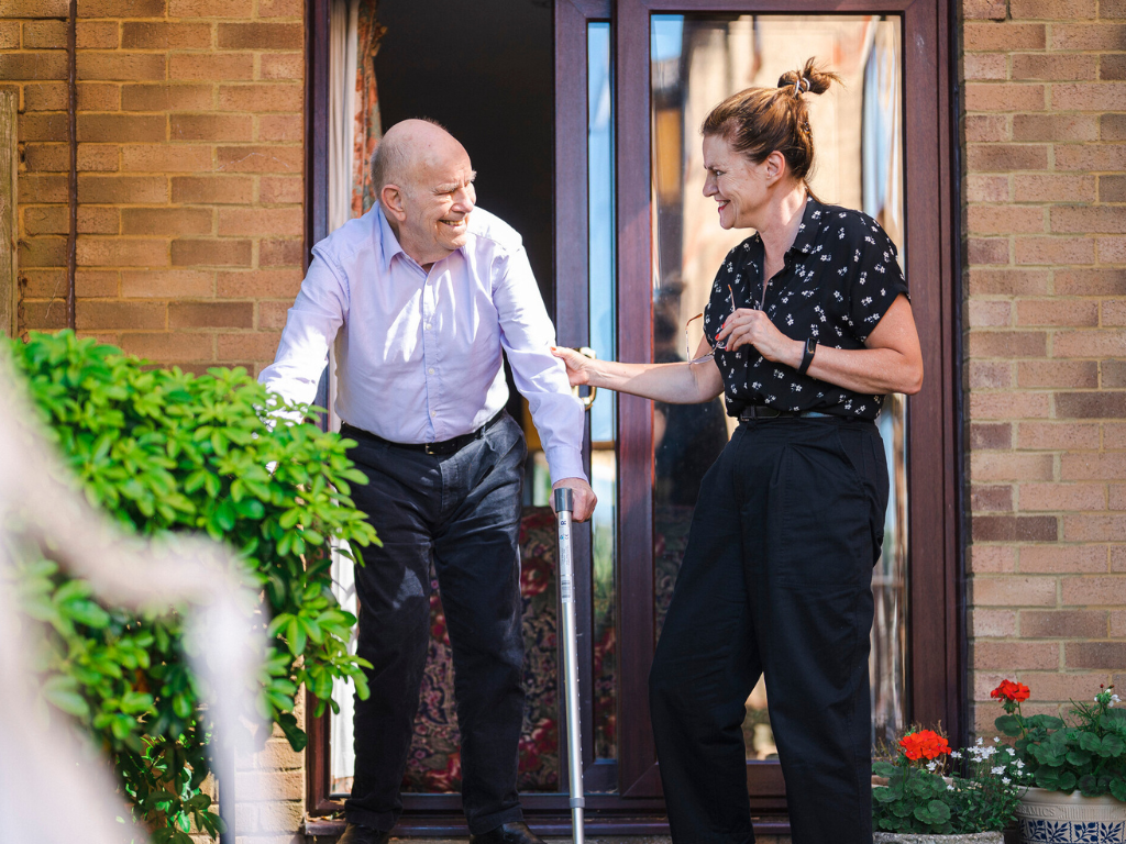 Ann helps her father outside their house door