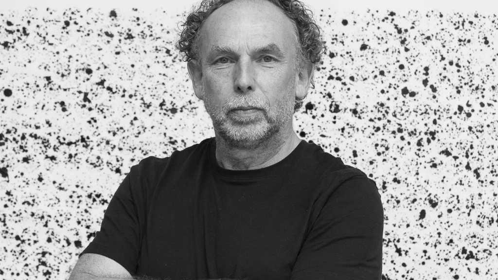 A black and white image showing Richard, who wears a black t-shirt, looking at the camera.